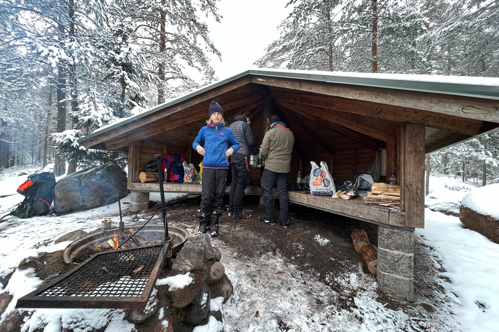 Några scouter är på äventyr i skogen och gör mat i en kåta